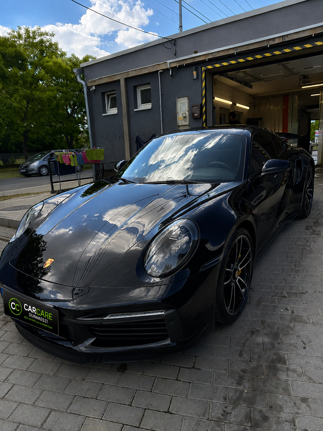 Fekete Porsche 911 elölnézetből a dunakeszi autókozmetika előtt